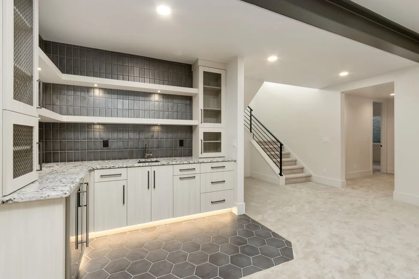 Custom lower-level bar with illuminated cabinetry