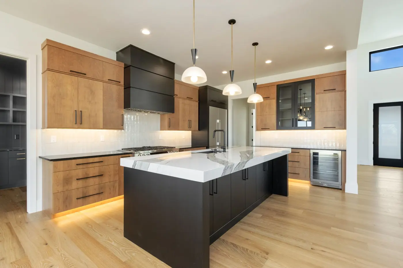 Custom kitchen with warm wood cabinetry and a waterfall island