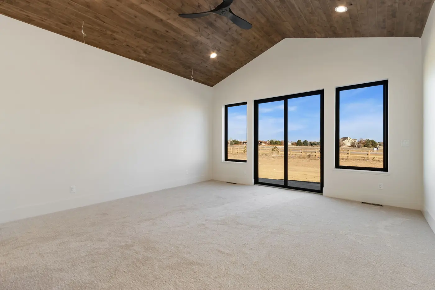 Primary bedroom with a wood ceiling and mountain-facing windows